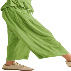 Close-up of green cotton harem pants showing the loose fit and textured fabric.