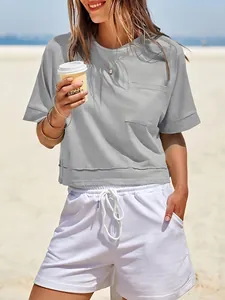 Vista dettagliata della t-shirt da allenamento corta e grigia oversize con taschino