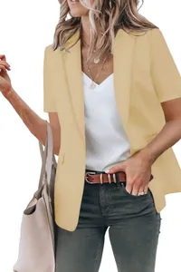 Detail view of a woman wearing a casual beige short-sleeved blazer over a white top