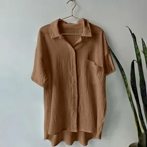 Macro detail of brown cotton linen shirt showing muslin texture and pocket detail