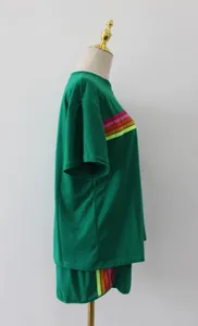 Side view of women's green loungewear set with colorful stripes on shirt and shorts