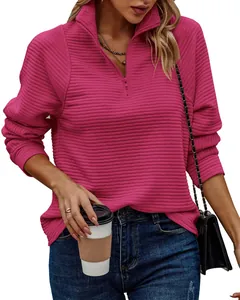 Detail of women's magenta half-zip ribbed sweatshirt showing textured fabric and fit