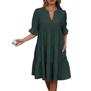 Elegante vestido verde oscuro con cuello en V, falda de capas y bolsillos laterales