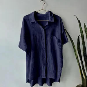 Detailed view of navy blue short-sleeved crinkle cotton linen shirt on hanger