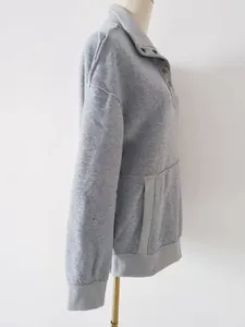 Side view of a grey women's sweatshirt with button collar and large front pocket