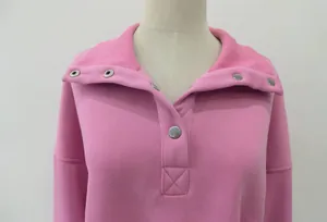 Detail shot of a pink Henley neck sweatshirt featuring silver metal buttons and lapel.