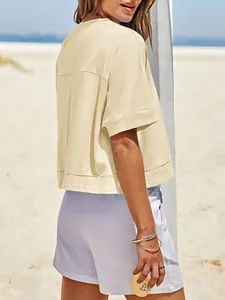 Vista posteriore dettagliata di una t-shirt crop top oversize crema a maniche corte per donna