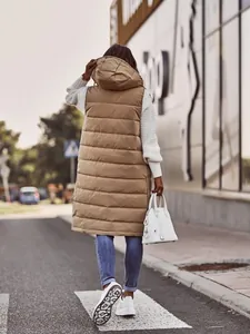 Back view of a stylish tan long hooded puffer vest worn with white knit sweater