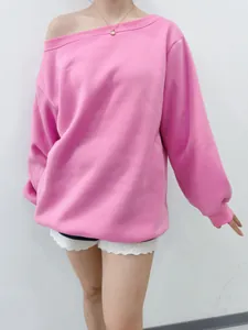 Close-up of pink off-the-shoulder sweatshirt featuring a relaxed asymmetric neckline.