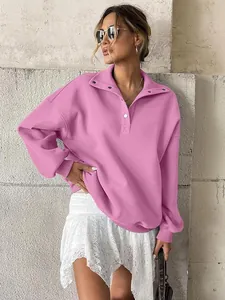 Oversized pink Henley sweatshirt with button-up collar shown on a stylish model