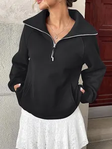 Dettaglio di felpa in pile nera da donna con mezza zip e pratiche tasche laterali incluse