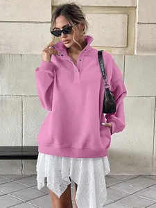 Stylish pink oversized Henley sweatshirt with buttons and fleece lining shown on model.