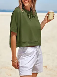 T-shirt crop top oversize verde oliva da donna in un ambiente balneare soleggiato