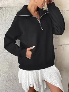 Primo piano di felpa nera oversize con mezza zip da donna e pratica tasca laterale