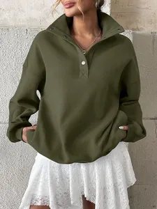 Close-up detail of an oversized olive green Henley sweatshirt featuring a button collar design