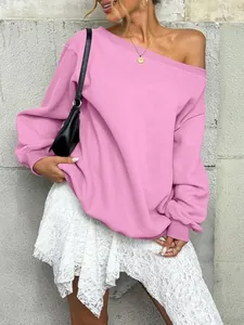 Detail of pink off-the-shoulder sweatshirt featuring ribbed cuffs and a relaxed loose fit