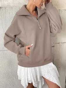 Dettaglio ravvicinato della felpa oversize da donna in pile con mezza zip e tasche kaki