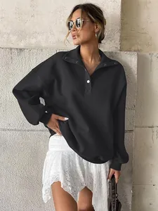Close-up of a black oversized fleece-lined Henley sweatshirt with a button collar.