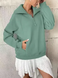 Dettaglio della felpa oversize in pile verde menta da donna con mezza zip e tasche