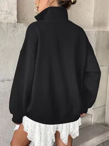 Back view of oversized black sweatshirt with ribbed cuffs and high collar detail