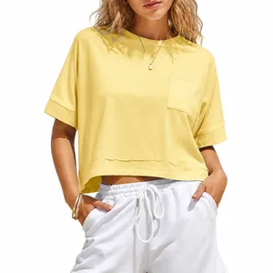 T-shirt crop top gialla oversize casual con tasca e pantaloncini bianchi.