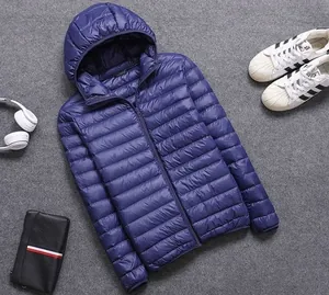 Close-up detail view of a men's lightweight blue hooded puffer jacket on grey background