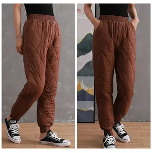 Detail view of brown quilted down cotton pants with elastic tapered cuffs for winter