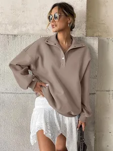 Close-up of women's oversized taupe Henley sweatshirt with button collar detail