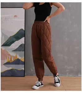 Detailed view of women's brown quilted down-cotton warm trousers with elastic cuffs