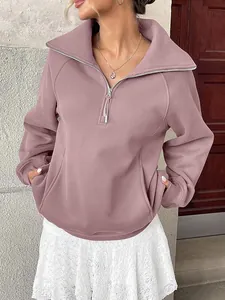 Dettaglio della felpa in pile color malva da donna con mezza zip e tasche anteriori.