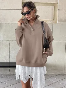 Fashionable woman wearing an oversized brown Henley collar sweatshirt with buttons