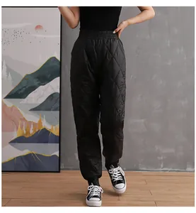 Detailed view of women's black quilted down pants with elastic waist and jogger cuffs