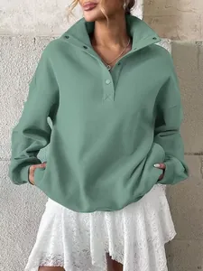 Detail of oversized green Henley sweatshirt with button collar and fleece lining