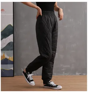 Full length side view of black quilted winter padded pants for women with tapered cuffs