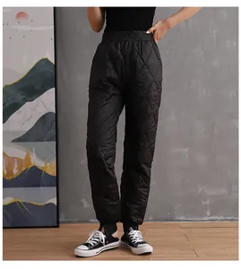 Front view of black quilted winter pants with elastic waist and jogger cuffs on model