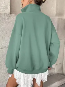 Back view of a cozy oversized sage green Henley sweatshirt featuring ribbed cuffs