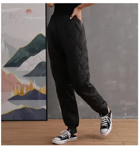 Close-up detail of black quilted down-cotton pants with high waist and elastic cuffed hem