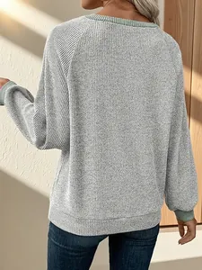 Πίσω όψη ενός casual πλεκτού πουλόβερ σε γκρι και μέντα με χαλαρούς πεσμένους ώμους