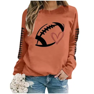 Detailed view of women's orange sweatshirt featuring football and heart graphic print