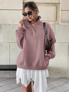 Close-up of pink oversized sweatshirt featuring a Henley collar with button details