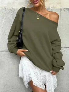 Stylish women's olive green off-shoulder sweatshirt paired with a white lace skirt outdoors