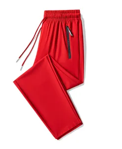Detail view of bright red ice silk sports pants for men with zippered pocket.