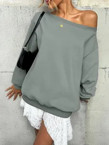 Detailed view of women's off-shoulder grey sweatshirt paired with a white lace skirt