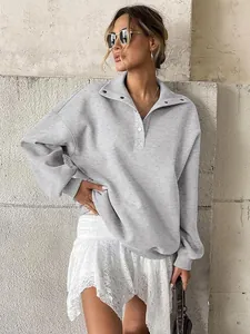 Close-up of women's oversized grey henley collar sweatshirt with fleece lining.