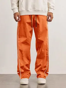 Pantalon streetwear rétro orange avec liserés blancs et taille élastique à cordon
