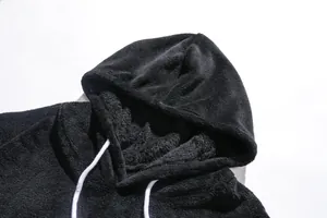 Vue détaillée de la texture polaire corail noire et de la capuche d'un sweat à capuche