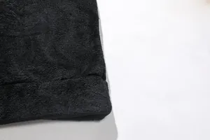 Gros plan de haute qualité montrant la texture douce du polaire corail noir du sweat à capuche