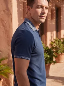 Detailansicht des dunkelblauen Herren-Poloshirts mit geometrisch gemustertem Kragen