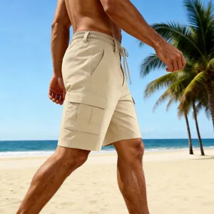 Side profile detail of men's khaki linen cargo shorts featuring a drawstring waist on a sunny beach.