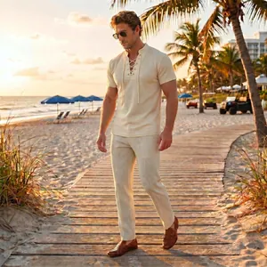 Men's two-piece summer leisure set featuring a lace-up shirt and textured trousers on a beach